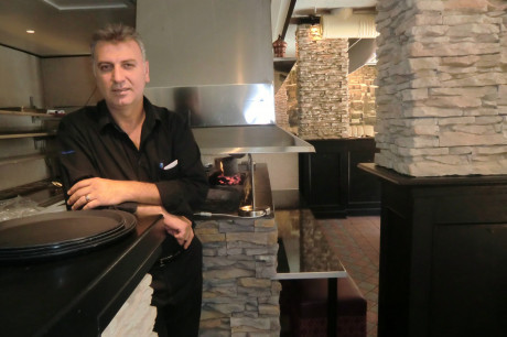 Hasan Tercan i restaurang Mezopotamia med tr&auml;kolsgrillen i bakgrunden